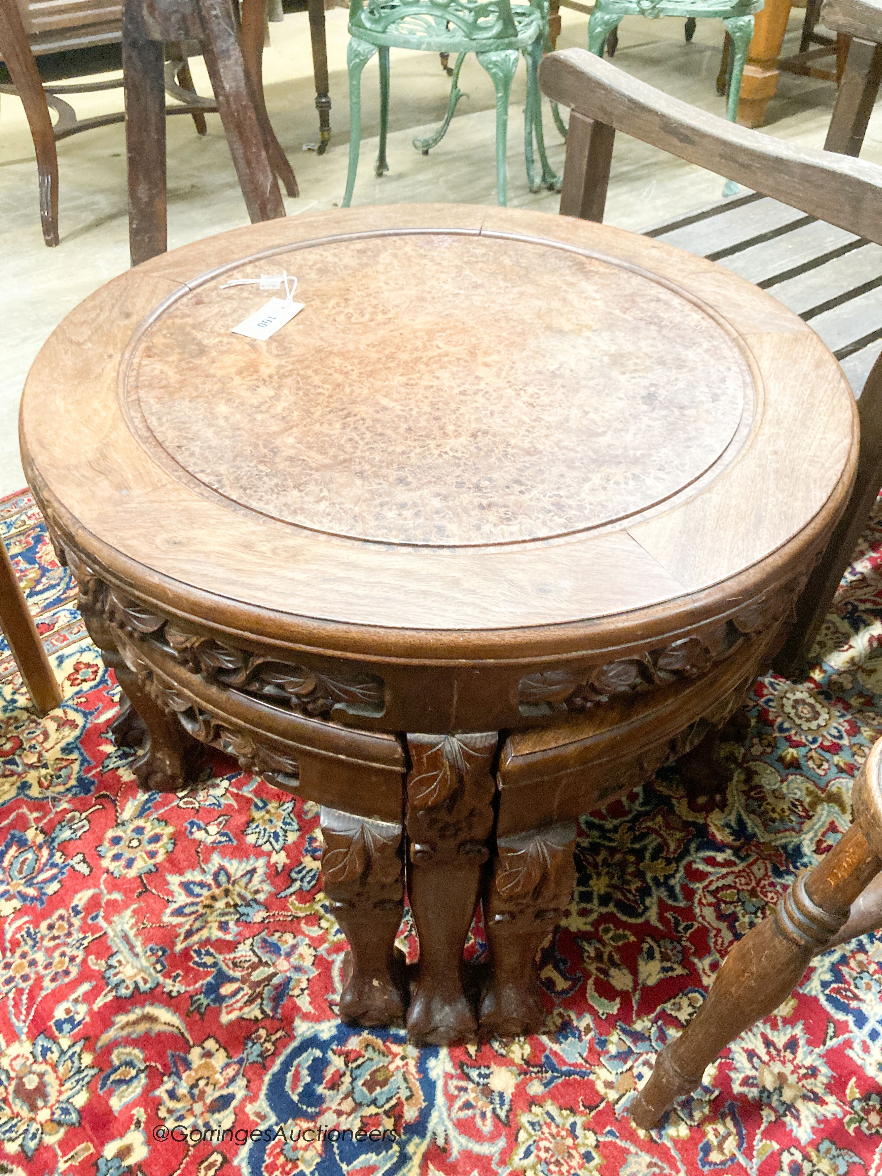 A Chinese circular carved hardwood circular low table with a burr wood centre panel and companion nest of four tables with claw feet, diameter 70cm, height 51cm